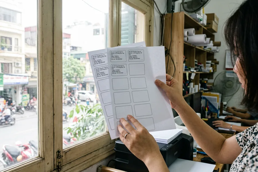 Đặt bản in thử lên tờ decal và soi ngược sáng để kiểm tra khung tem