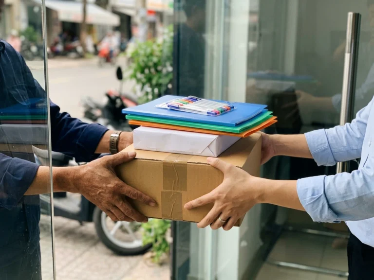 Nhân viên Phúc Thịnh trao thùng giấy in, bìa hồ sơ và bút bi cho khách tại văn phòng đường Lê Duẩn, phường Sài Gòn, Quận 1